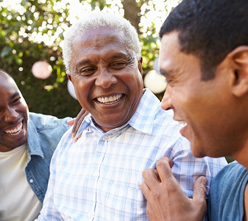 Dentures patient in Raleigh smiling with family