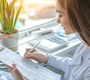 Person filling out dental insurance document