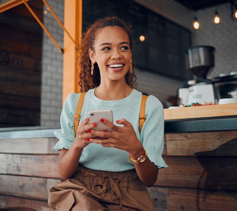 Smiling woman sitting on barstool at restaurant