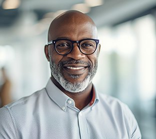 Man in button-up shirt smiling at work