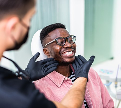 Dentist looking at smiling patient's teeth