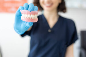 Dental lab technician holding dentures