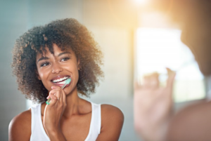 Woman brushing her pristine teeth in mirror