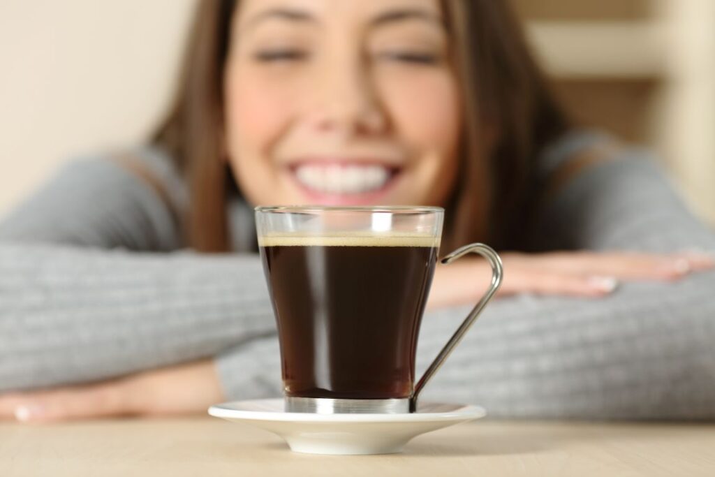 A woman looking at a cup of coffee